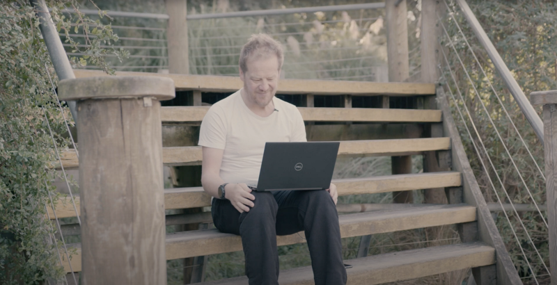 Bry Wilson sat on steps typing on laptop Dr Bryan Wilson sat on steps typing on laptop